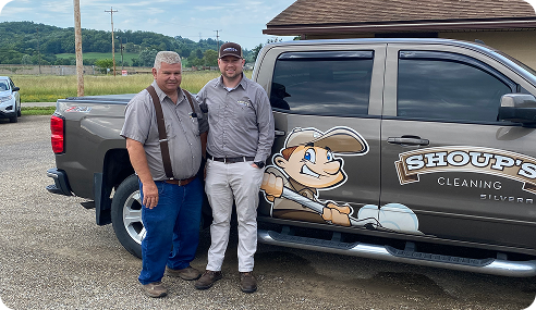 Two men stand by a Shoup’s Cleaning truck with a cartoon mascot logo, providing professional services in Ohio.